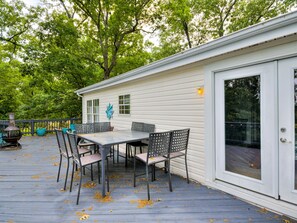 A covered outdoor deck with a table and chairs, a grill, and a decorative star. - Lake Front Beauty (Eucha)