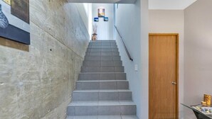 A staircase leading to a wooden door, with a vase and framed pictures on the wall. - Soak up breathtaking sunsets from any of our three private balconies!
 (Rincon)
