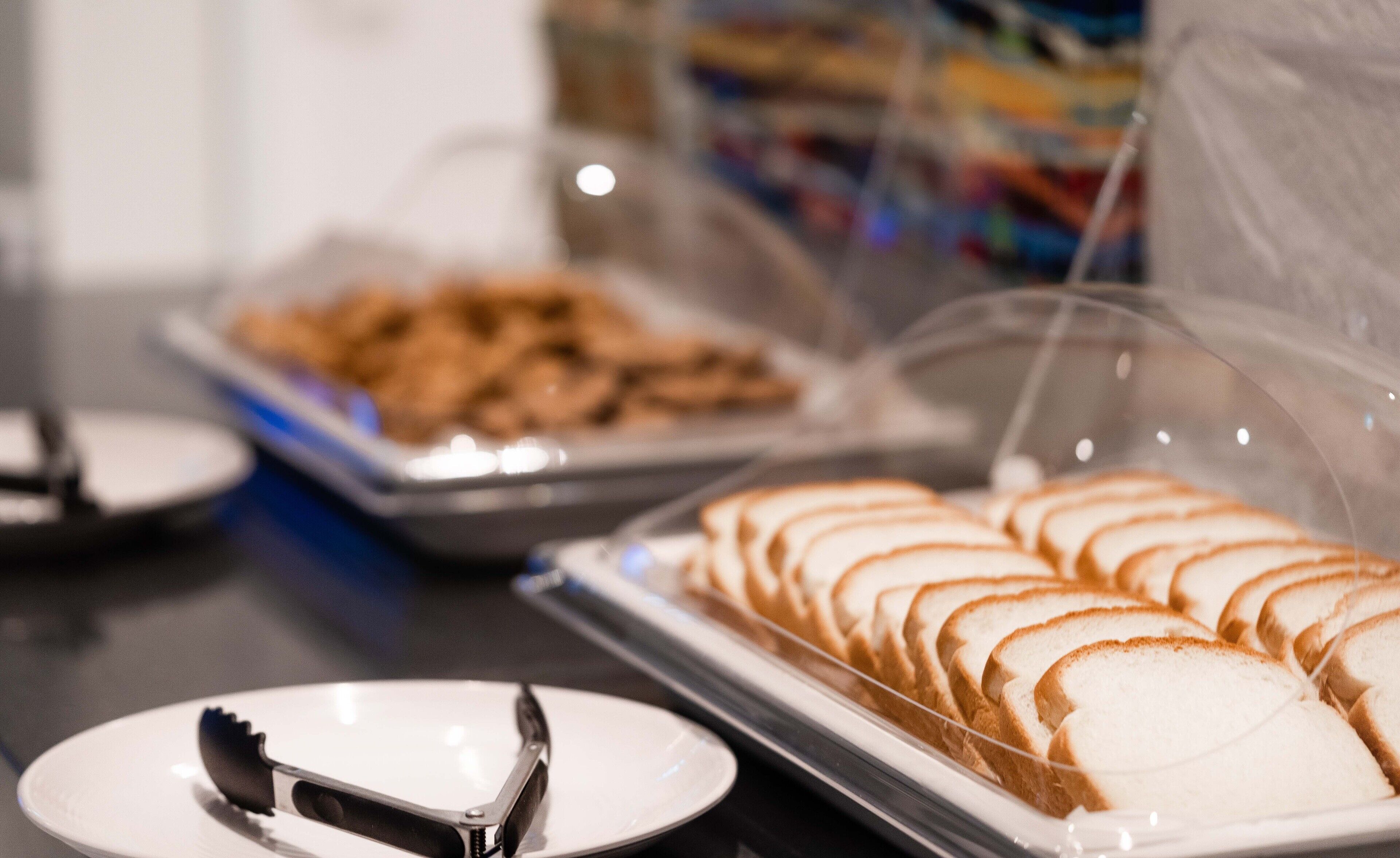 A buffet with sliced bread and a plate with a knife.