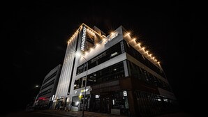 Ein modernes Hotelgebäude mit einem markanten '101 Tower' Schild, mehreren Etagen und beleuchteter Außenfassade.