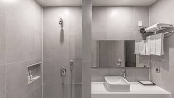A modern bathroom with a walk-in shower, a sink, and a mirror.