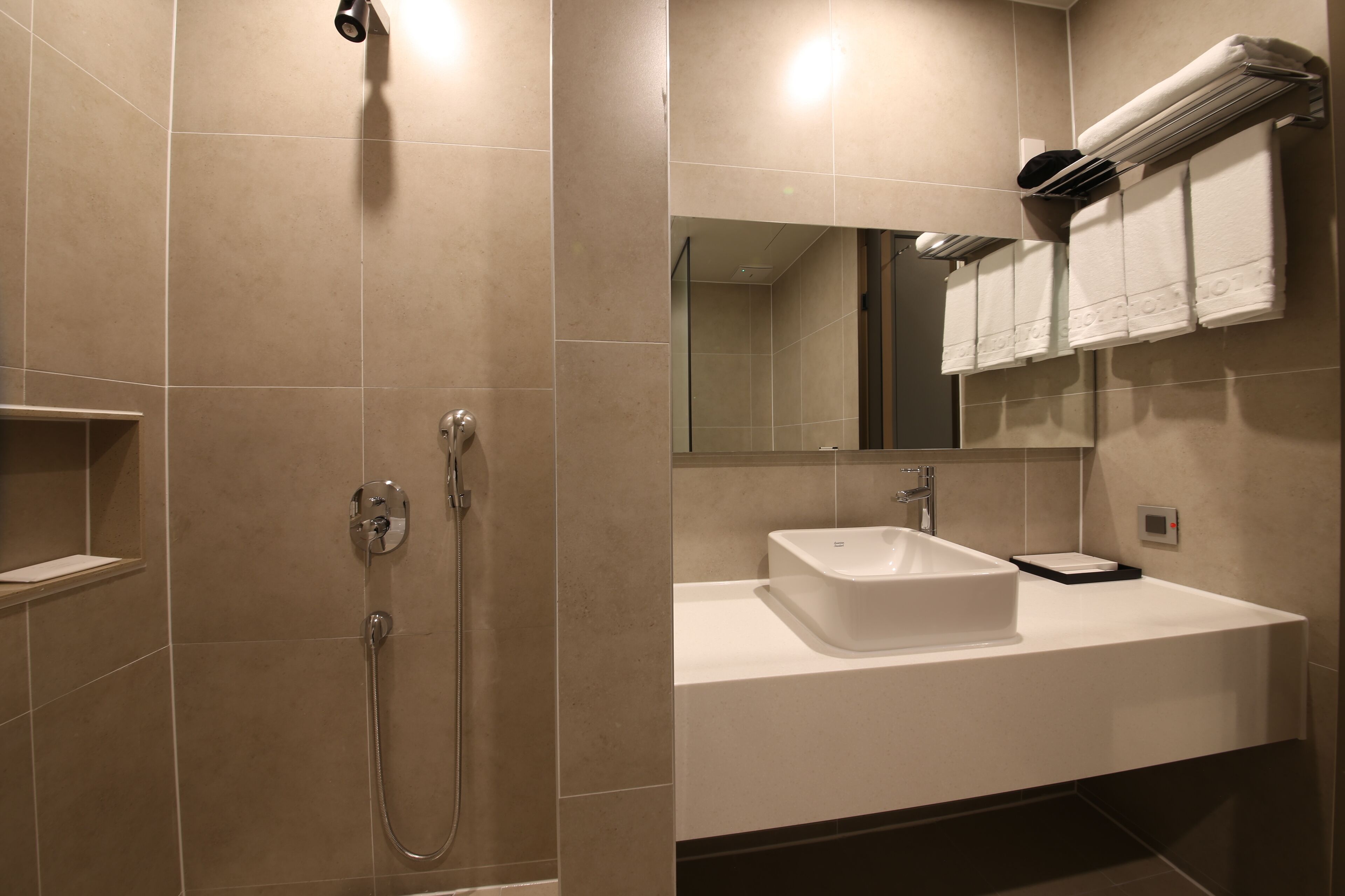 Ein modernes Badezimmer mit Dusche, Waschbecken und Handtuchhalter.