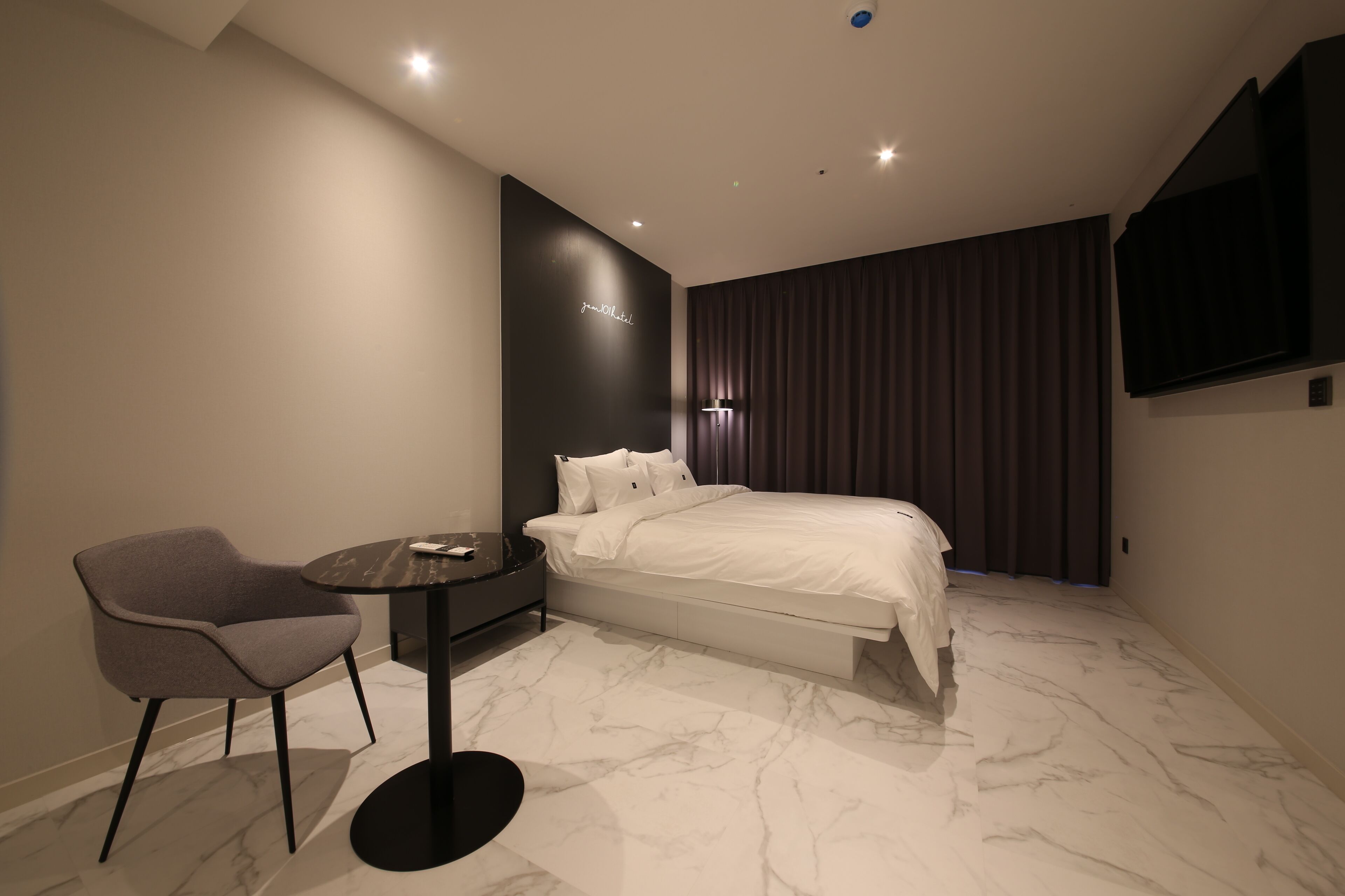 Een moderne hotelkamer met een bed, een bureau en een stoel.