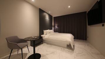 Een moderne hotelkamer met een bed, een bureau en een stoel.