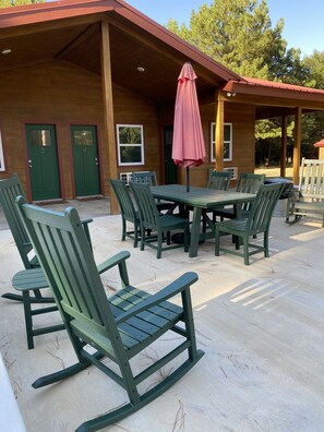 Enjoy al fresco dining on the patio with a table and six chairs, shaded by a colorful umbrella.