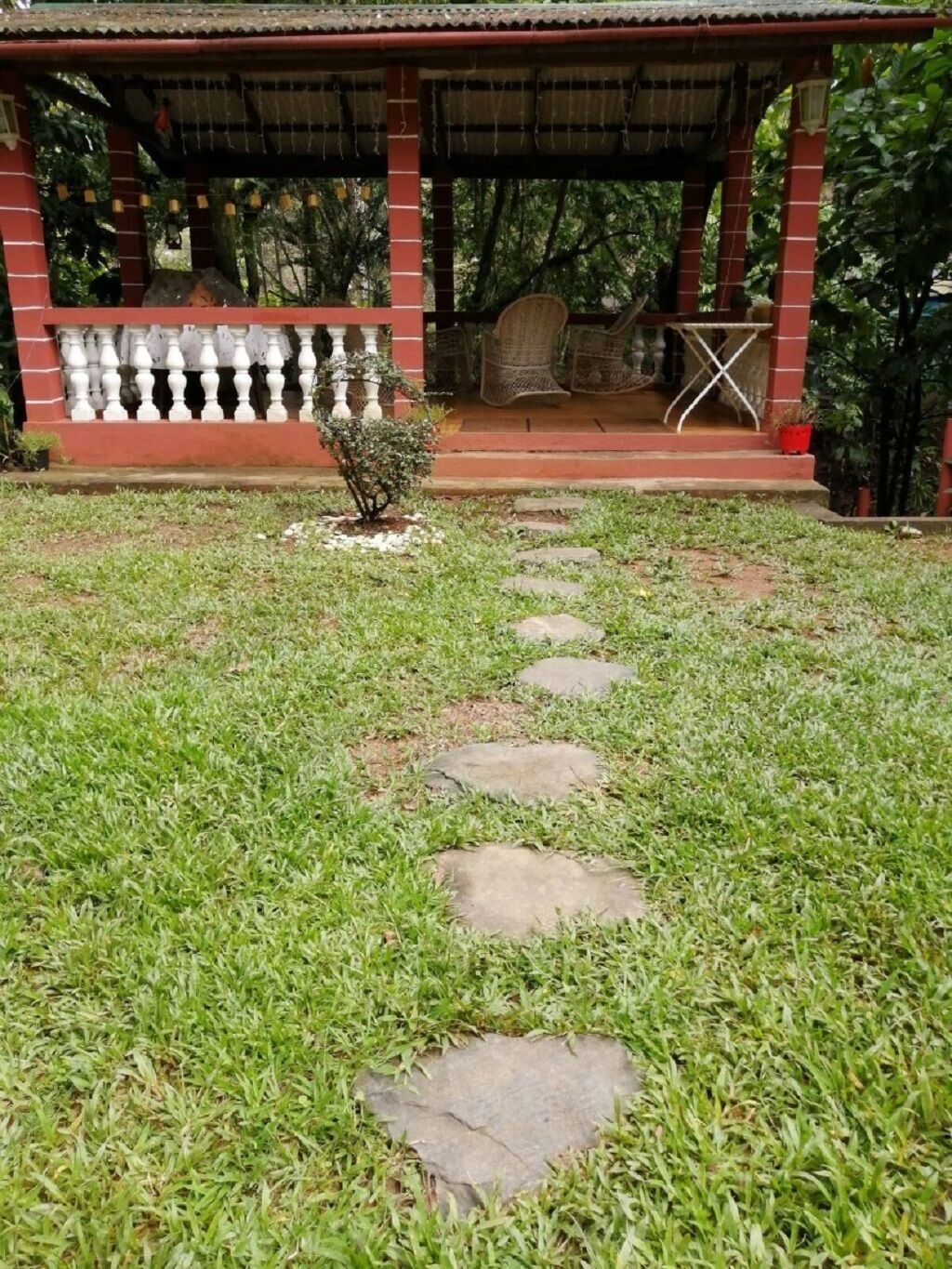Un porche cubierto con un sendero de piedra que lleva a un pequeño jardín.