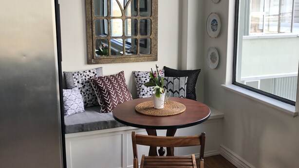A kitchen with a wooden table, a bench, and a refrigerator. - Uptown in Downtown (Anchorage)