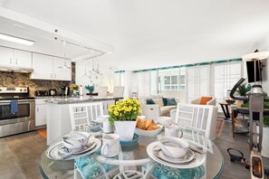A modern kitchen with white cabinets, a granite countertop, and stainless steel appliances.