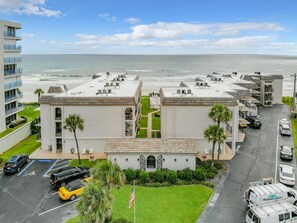 Un hotel frente al mar con varias edificaciones, estacionamiento y vista al océano.