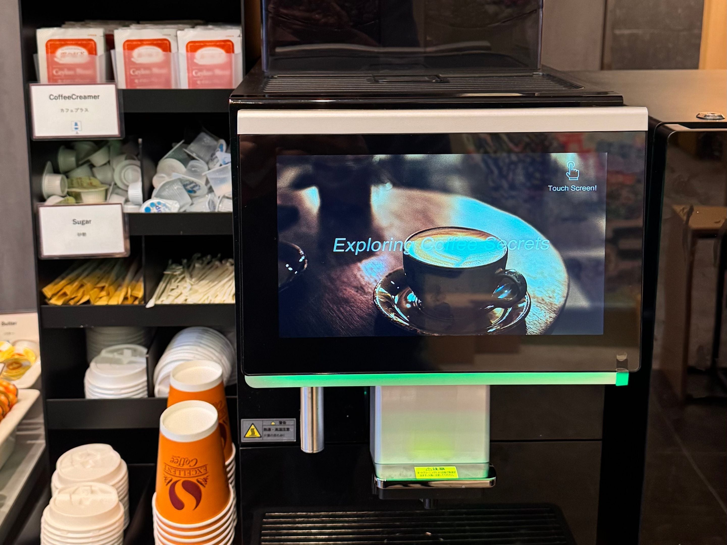 Una cafetera con pantalla táctil que muestra una taza de café.