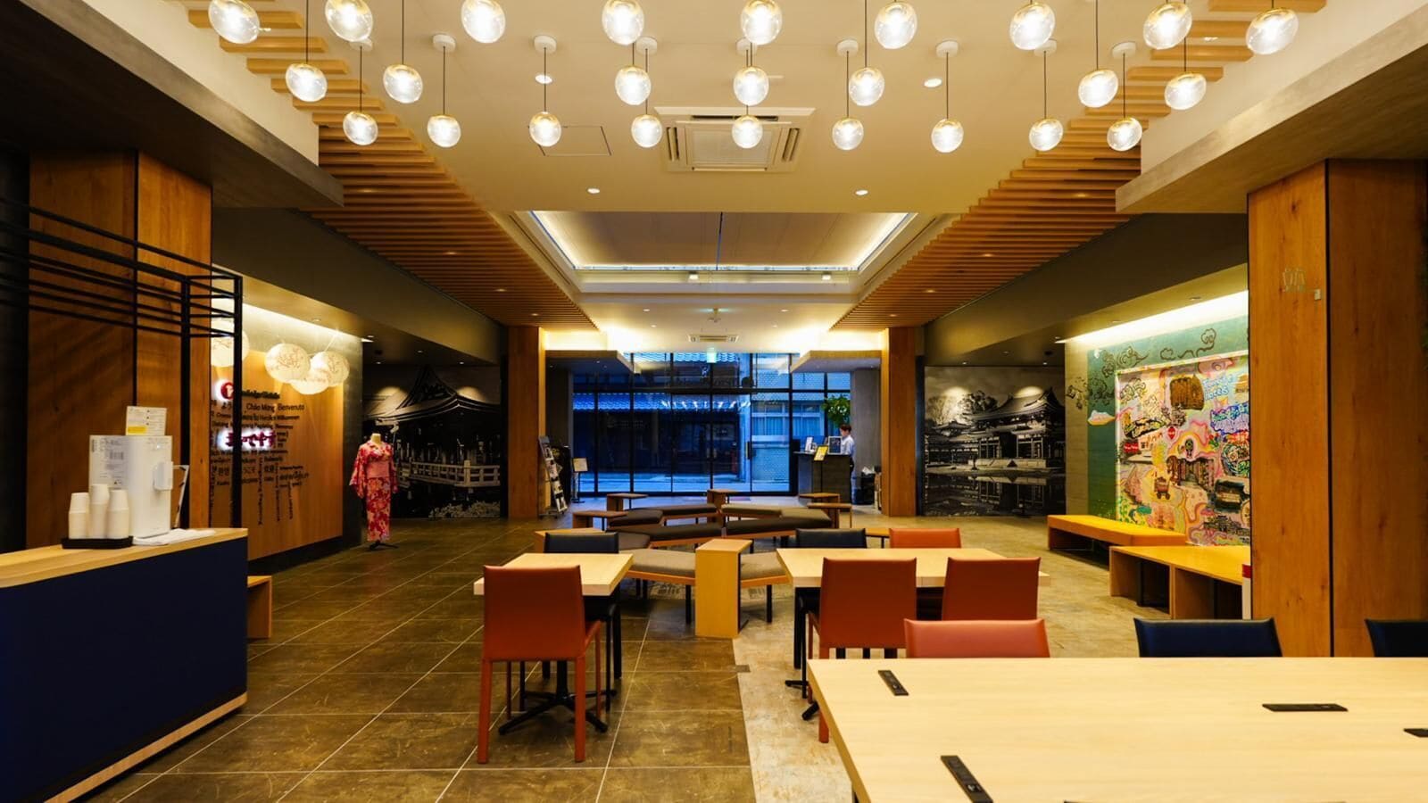 Un restaurante moderno con detalles de madera, varias mesas de comedor e iluminación colgante esférica.