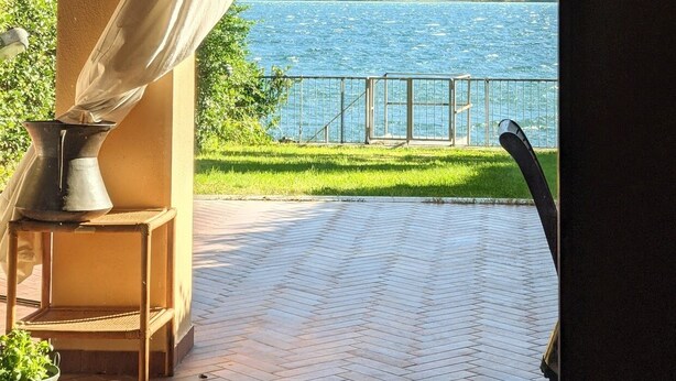 Un espace extérieur abrité offrant une vue sur un lac et des collines.