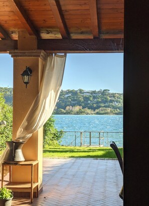 A covered outdoor area with a view of a lake and hills. - The House by the Lake - Trevignano Romano (Trevignano Romano)