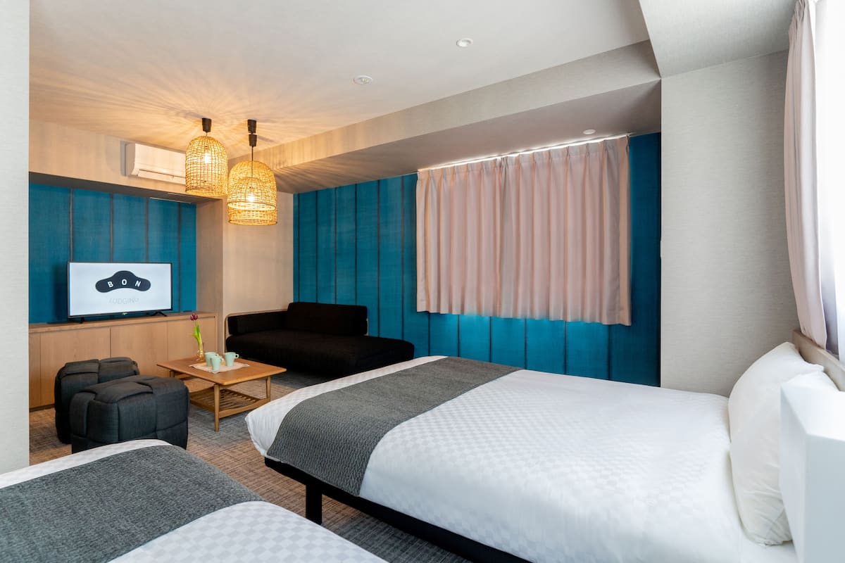Une chambre d’hôtel moderne avec un grand lit, un canapé, une télévision et une petite table.