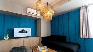 A modern room with a blue accent wall, a black sofa, a wooden table with two mugs, a TV on a wooden cabinet, and a wicker pendant light. - BON Kyoto Kiyomizu (Kyoto)