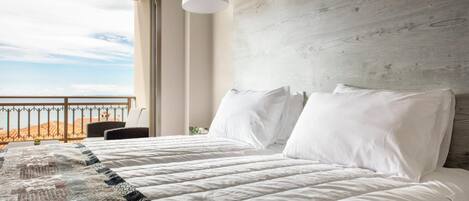 Ein Schlafzimmer mit einem großen Bett, Blick auf die Wüste durch ein Fenster und einem Holzkopfstück.