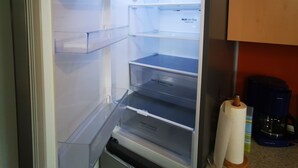 An open refrigerator with multiple shelves and a fresh converter drawer.
