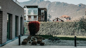 Un edificio moderno con fachada de ladrillo, sección de madera y un balcón.