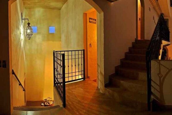 Un escalier avec une rampe métallique menant à un palier.