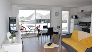 A modern apartment with a dining area, a sofa, and a kitchen. - Superb T3 apartment in a quiet location overlooking the port of Crouesty (Arzon)