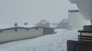 Un paysage enneigé avec des bâtiments et une clôture.