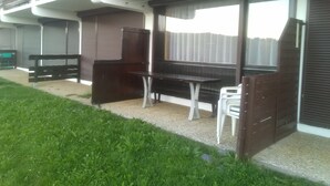 Un bâtiment doté d’un espace extérieur abrité comprenant un barbecue, une table et des chaises.