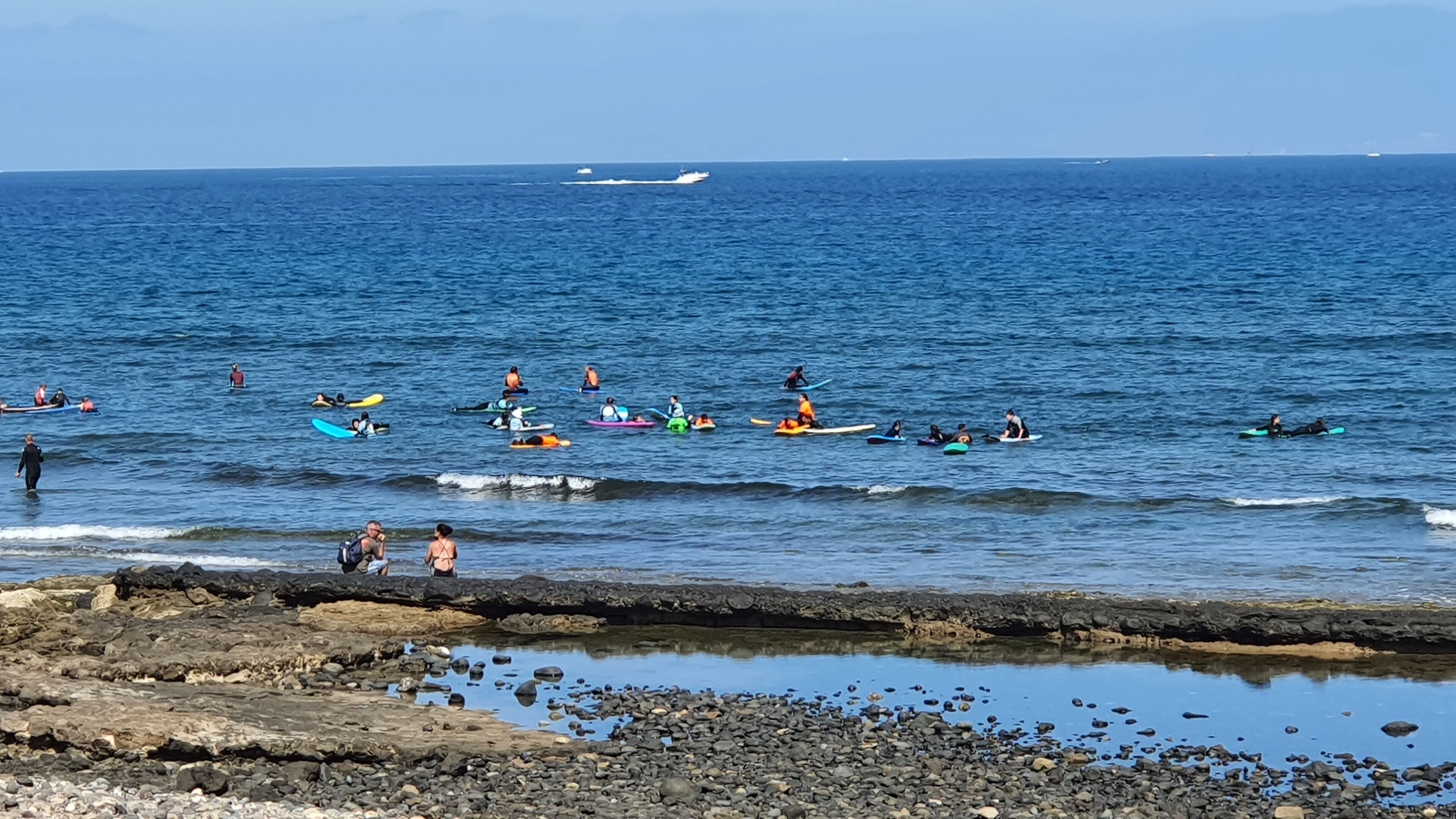 A beach with kayakers and surfers.