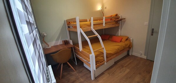 A bunk bed with a desk and chair, a small table, and a wall-mounted light. - Villa Babeth (La Rochelle)