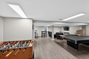 A room with a foosball table, ping pong table, and a television. - Perfect Lake House  Getaway (Vandalia)