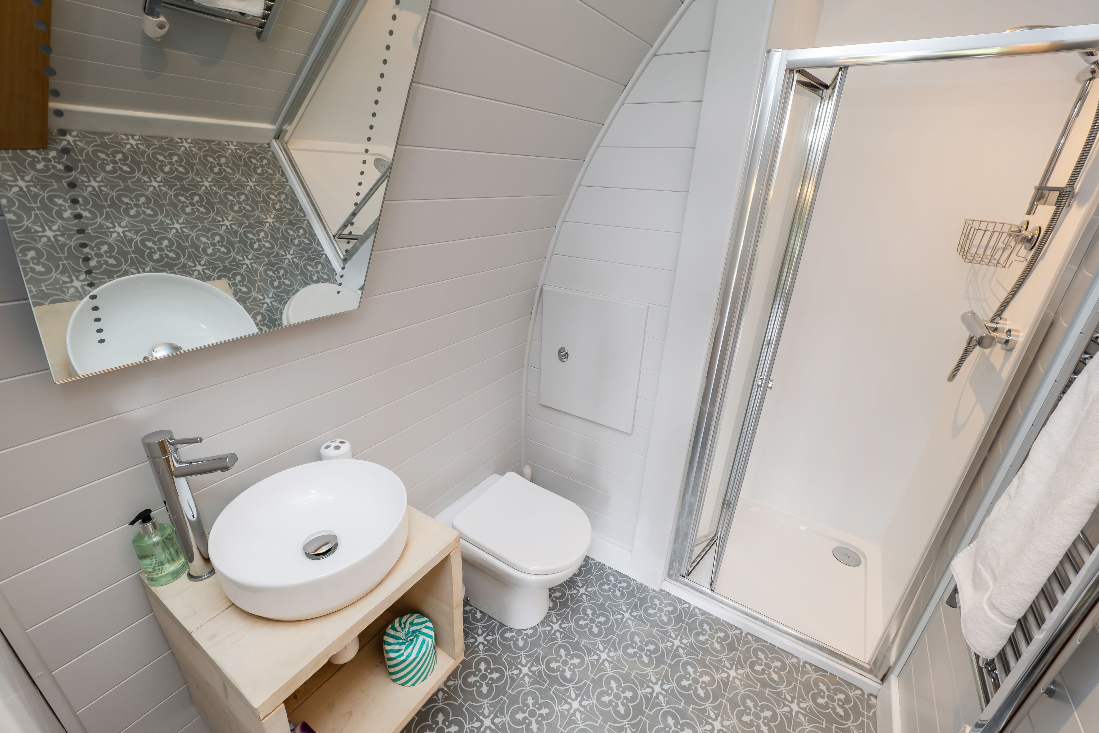 A bathroom with a white sink, toilet, and shower.
