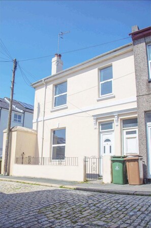 A two-story house with a white facade, a chimney, and a gated entrance. - Spacious 4 Bedroom House in Plymouth City Centre (Plymouth)