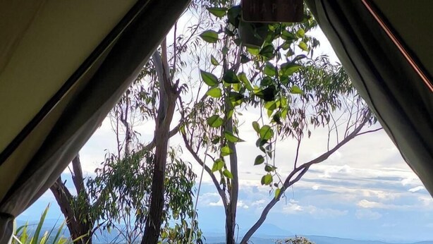 A tent with a view of a mountainous landscape.
