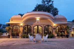 Un bâtiment traditionnel doté de fenêtres en arc de cercle et d’une enseigne indiquant l’accueil.