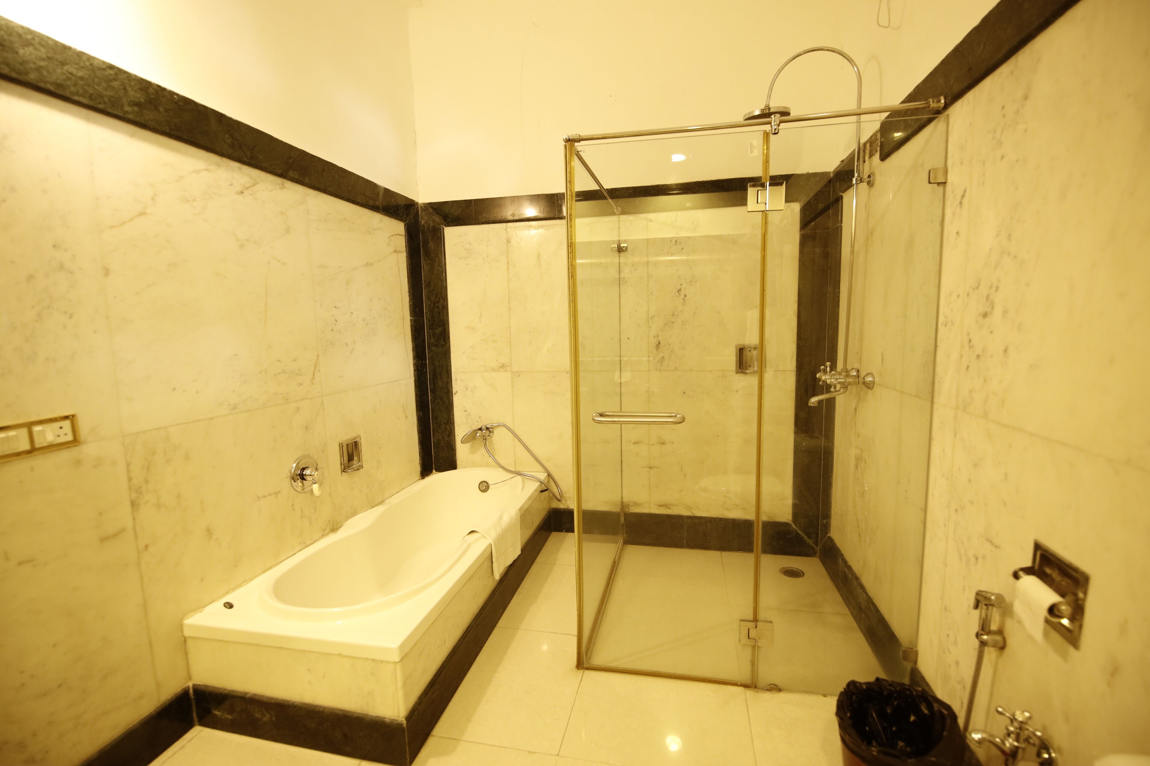 Ein modernes Badezimmer mit einer gläsernen Duschkabine, einer freistehenden Badewanne und einem WC.