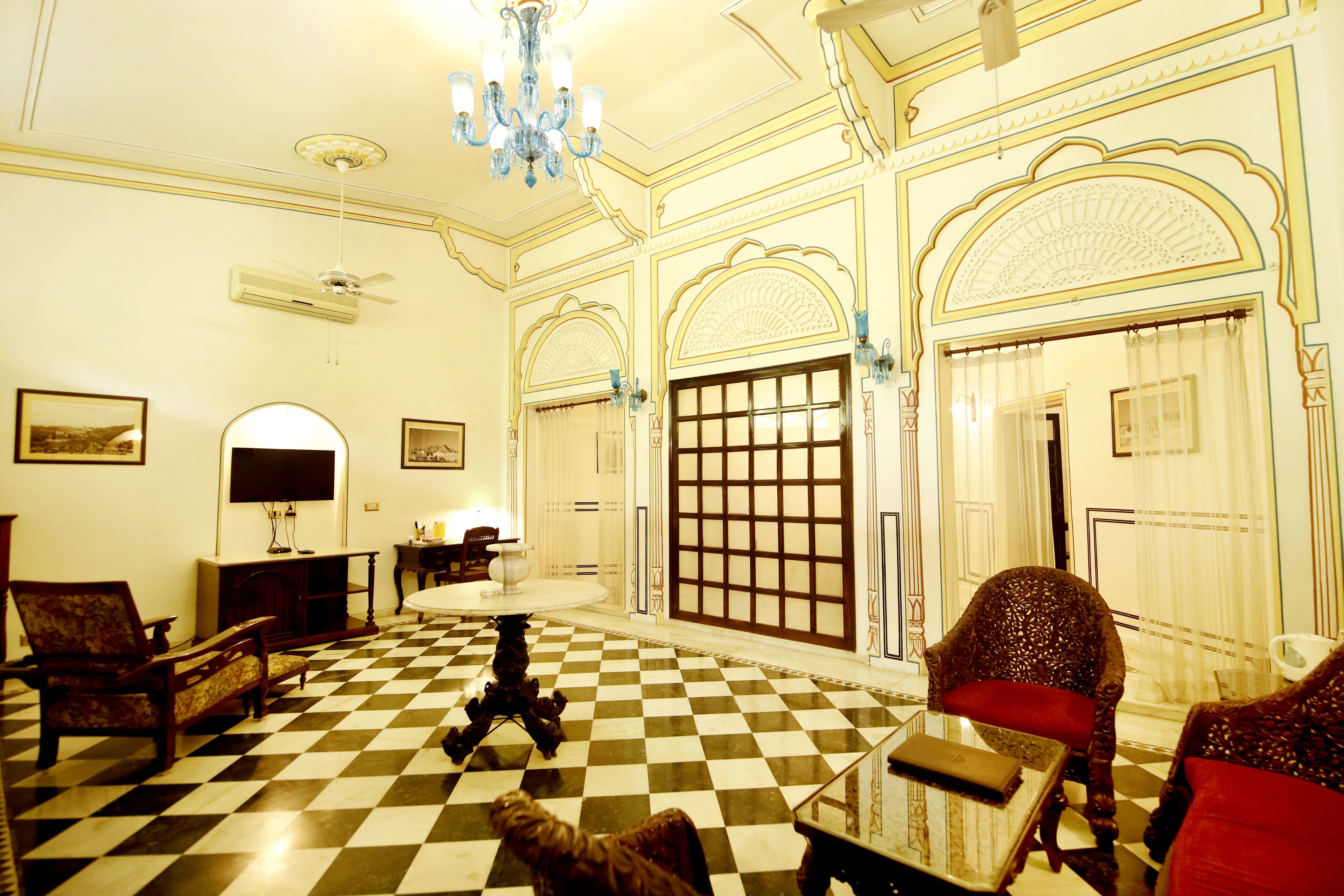 Una habitación con piso a cuadros, un candelabro y decoración tradicional.