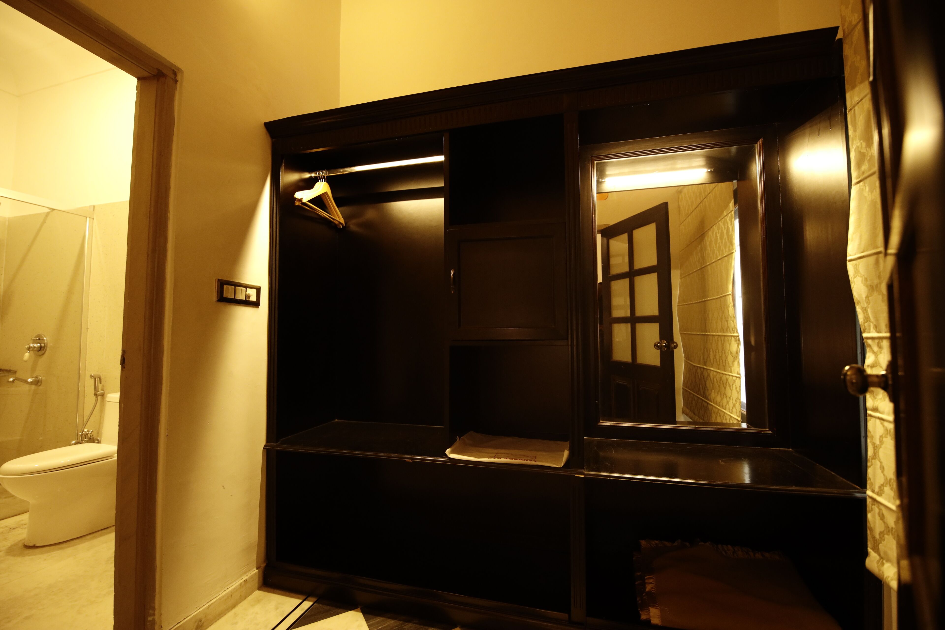 A bathroom with a toilet, a mirror, and a shower area.