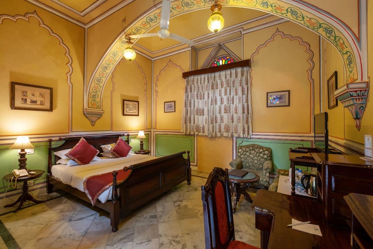 Une chambre classique, équipée d’un lit, d’un bureau et d’une chaise.