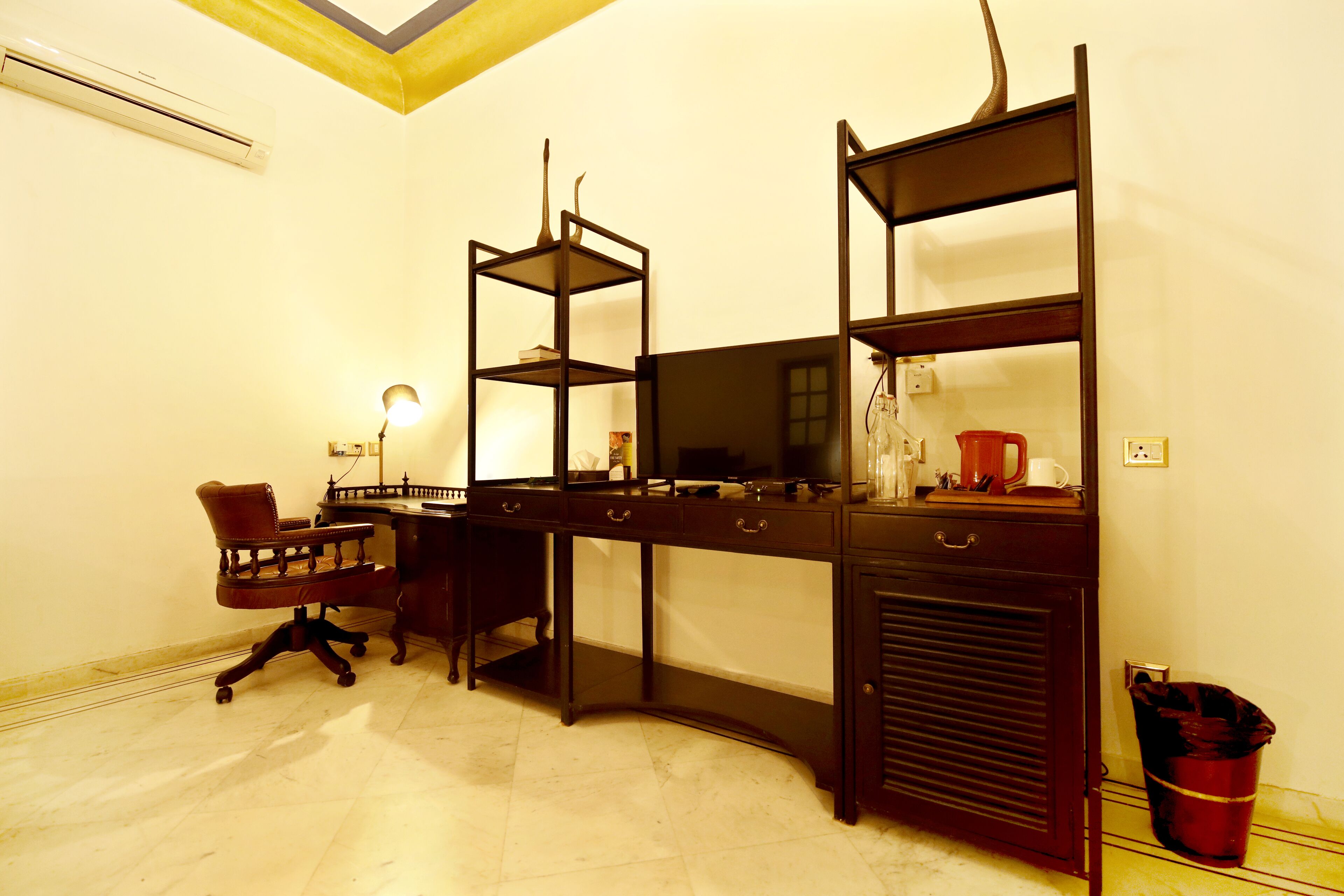 Una habitación con escritorio, silla y estanterías.