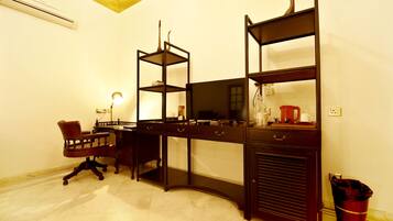 Una habitación con escritorio, silla y estanterías.