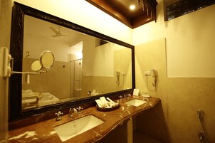 Casa de banho com duas pias, um espelho grande e um ventilador de teto.