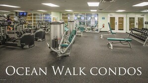 Une salle de sport équipée de tapis de course, d’appareils de musculation et de bancs.