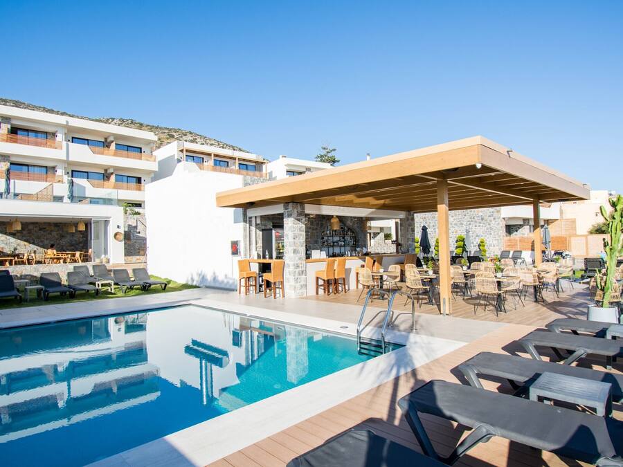 A poolside area with lounge chairs, a bar, and a covered seating area.