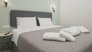Et moderne hotelværelse med en stor seng, et natbord og et lille rundt bord.