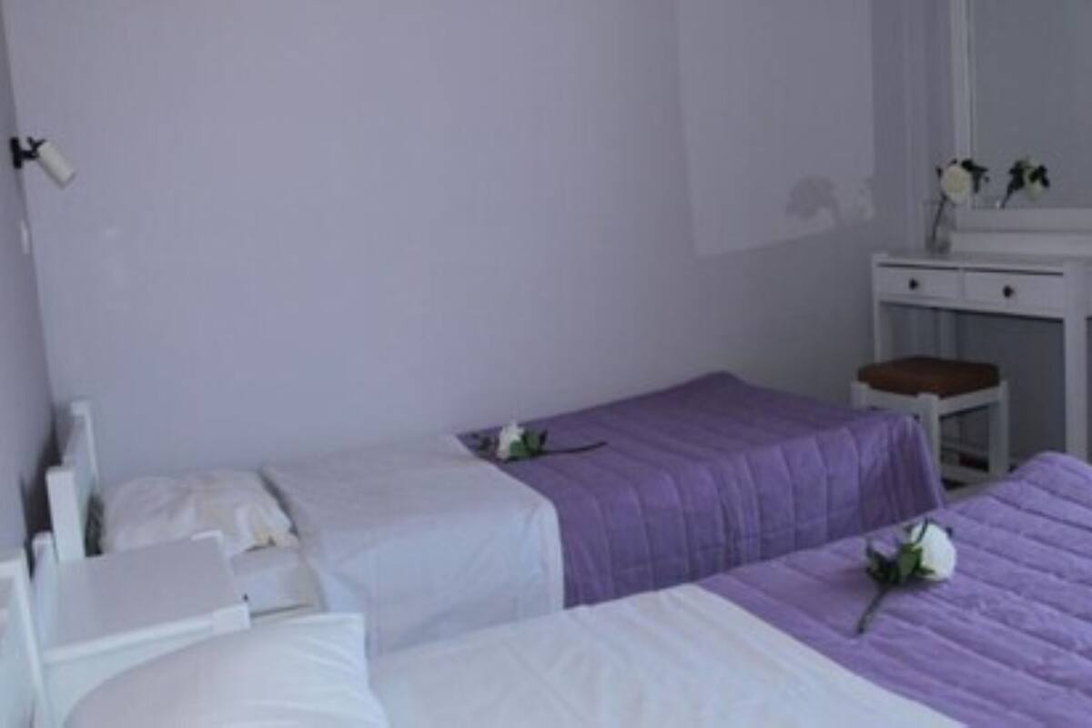 Ein Zimmer mit zwei Betten, einem kleinen Tisch und einem Spiegel.