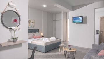 A modern bedroom with a bed, bedside table, and a TV on the wall.
