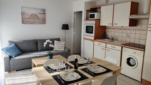 Ein kompakter Wohnbereich mit Küchenzeile, Essplatz und Sofa.