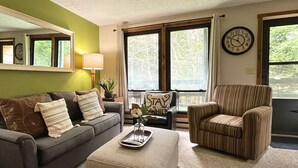 Ein Wohnzimmer mit Sofa, Sesseln und einem Couchtisch mit Tablett.