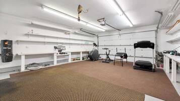 A gym with exercise equipment, a treadmill, and a stationary bike.
