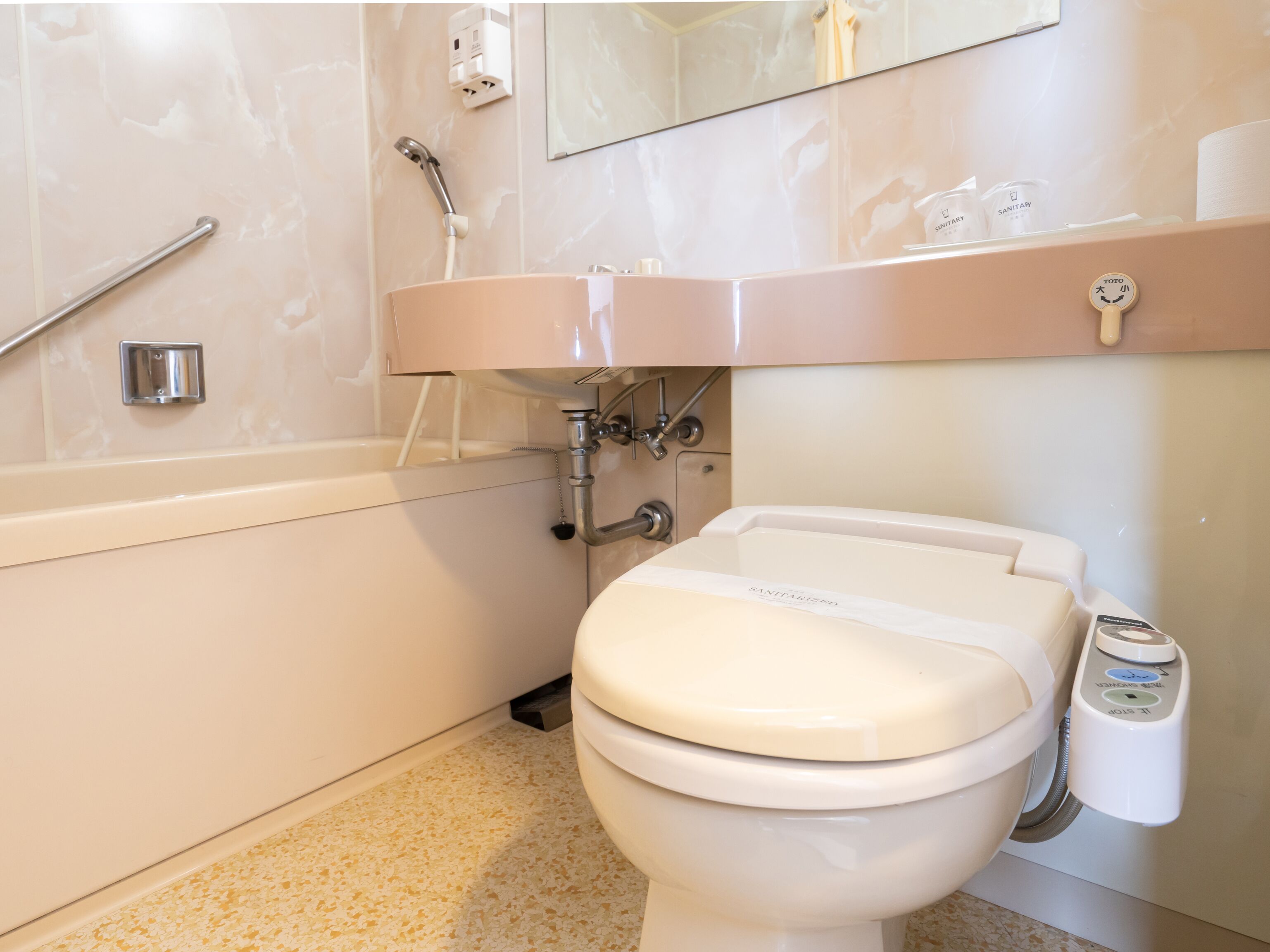 A modern bathroom with a toilet, sink, and bathtub.