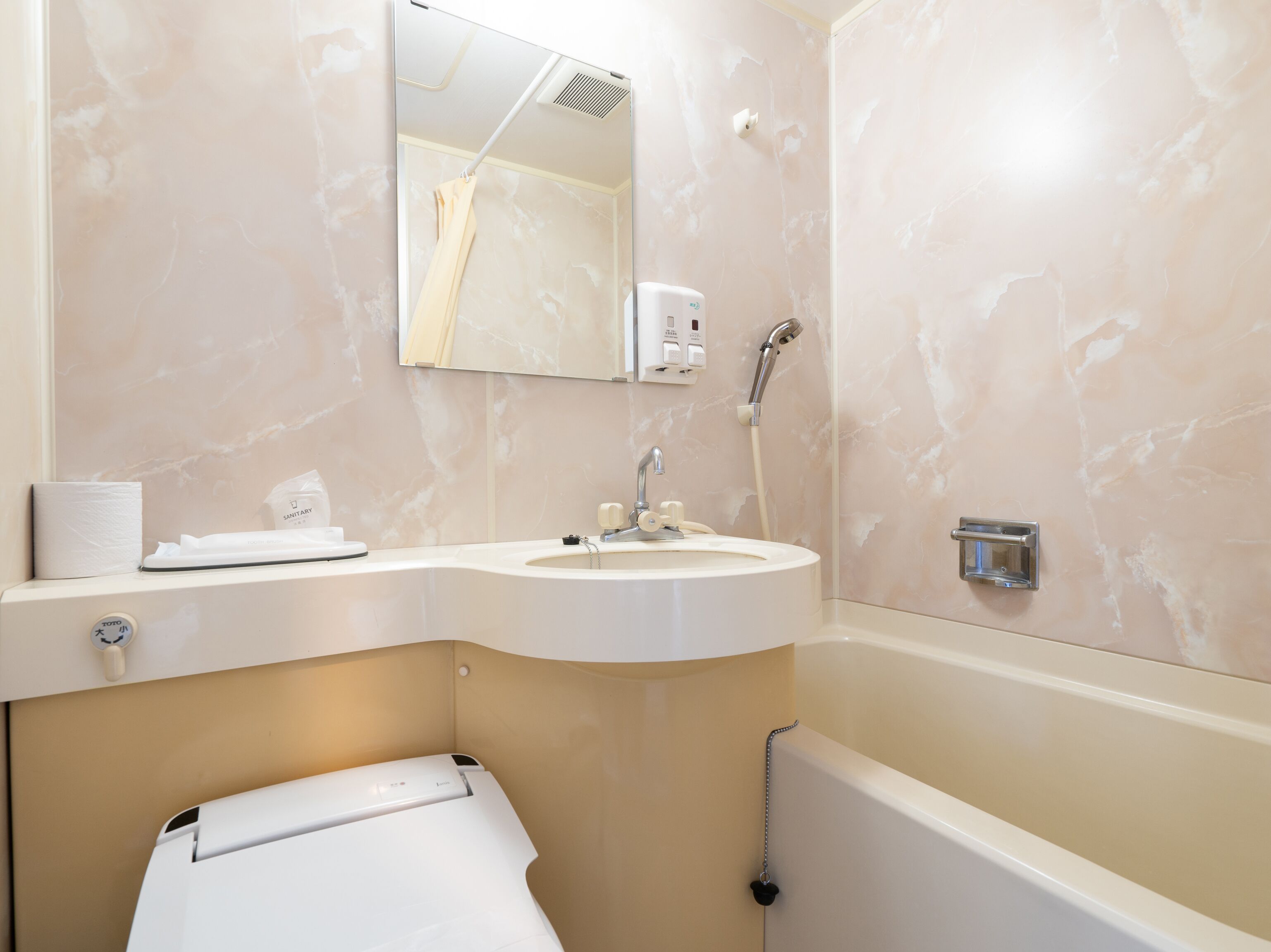 A bathroom with a sink, mirror, shower, and toilet.